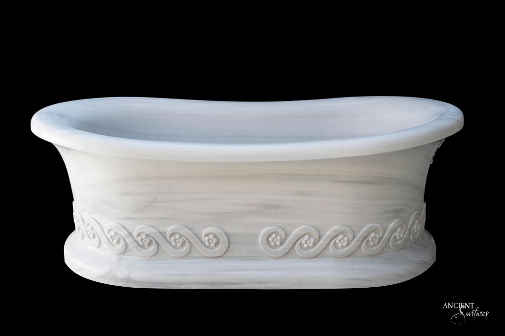 Engraved Limestone Bathtub by Ancient Surfaces, offering historical depth and classical elegance with intricate carvings inspired by Greek bathhouses and Baroque architecture.