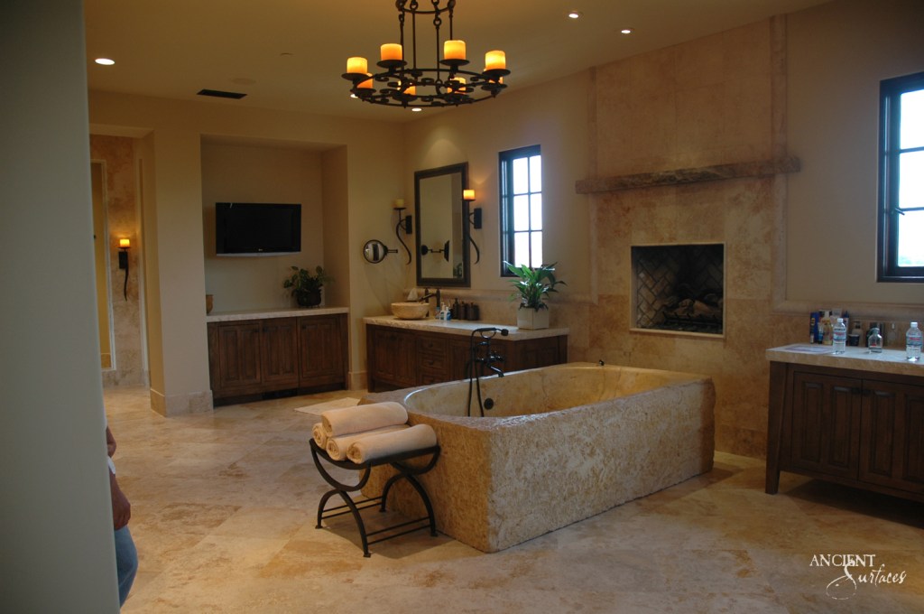 Stunning limestone bathtub by Ancient Surfaces, featuring intricate carvings and a weathered texture that exudes a sense of history, grandeur, and craftsmanship